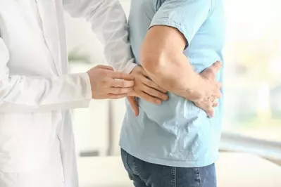doctor feeling on the back of patient for kidney stones